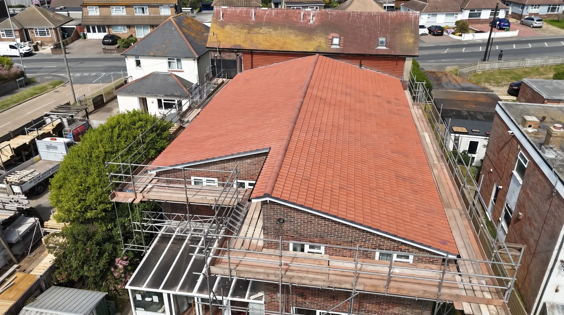 Completed terracotta clay tiled roof with scaffolding in place